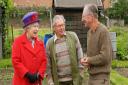 Queen Elizabeth II talks to gardening enthusiasts Donald Doody (left) and John Harrison on their allotment, in Redbridge Lane West, during her Golden Jubilee visit to east London.