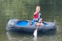 Eddie Schofield, 7, paddling in his homemade milk bottle boat