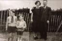 Derek Hall (second from the left) with his brother and parents by the crater in his back garden in Hainault in 1941. Photo: Derek Hall.