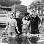 Two British sailors and their girlfriends wading in the fountains in Trafalgar Square on VE Day, 8 May