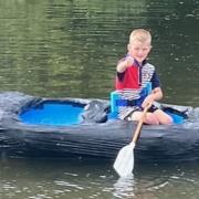 Eddie Schofield, 7, paddling in his homemade milk bottle boat