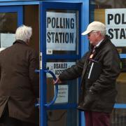 Voters arrive at a polling station