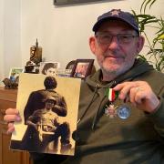 Warren Grynberg, with a picture of his father Herschel, along with his father's service medals.