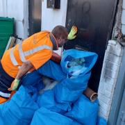 A street cleansing worker beside large pile of fly-tipped waste