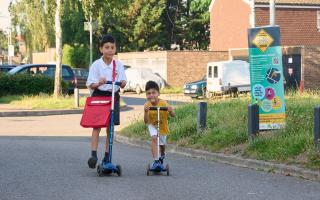 Two Fullwood Primary School pupils scooting to school.